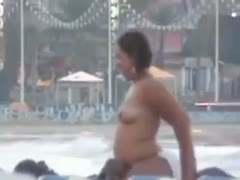 On a public beach, a dirty brown-skinned girl mounts her companion.